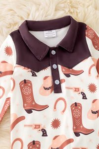 Baby boy romper with cowboy print on a textured surface