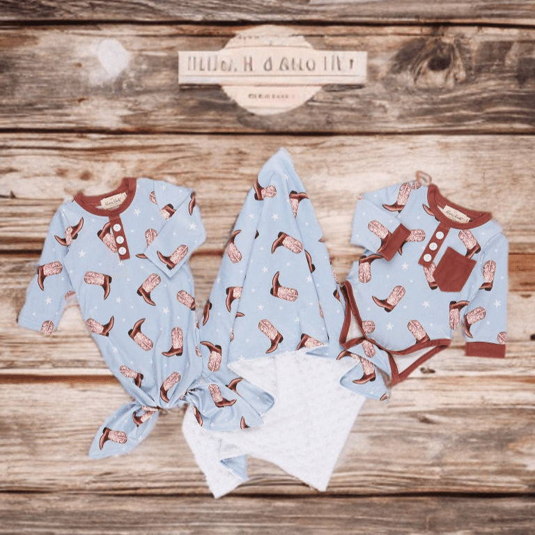 Baby outfit set with cowboy print on a wooden surface
