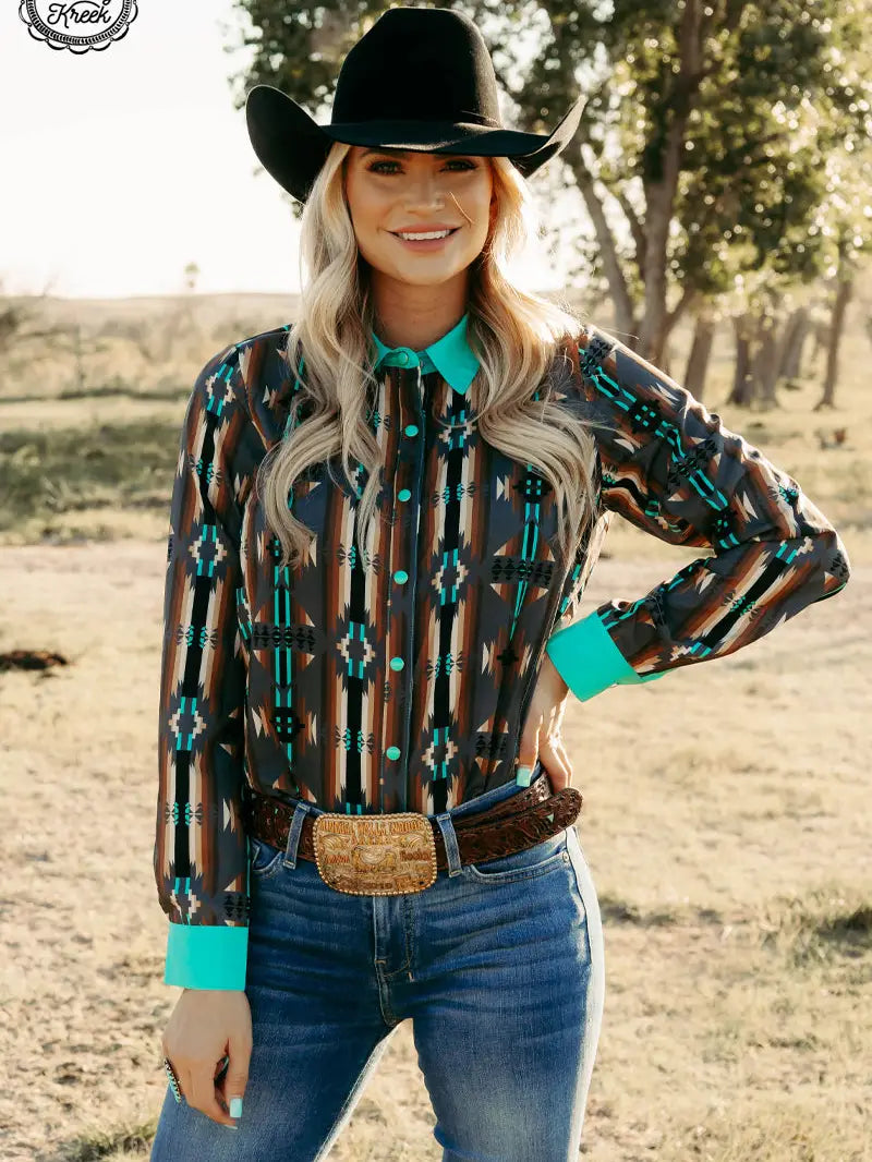Woman modeling western Red Dirt Road Top with turquoise collar and cuffs, standing outdoors.