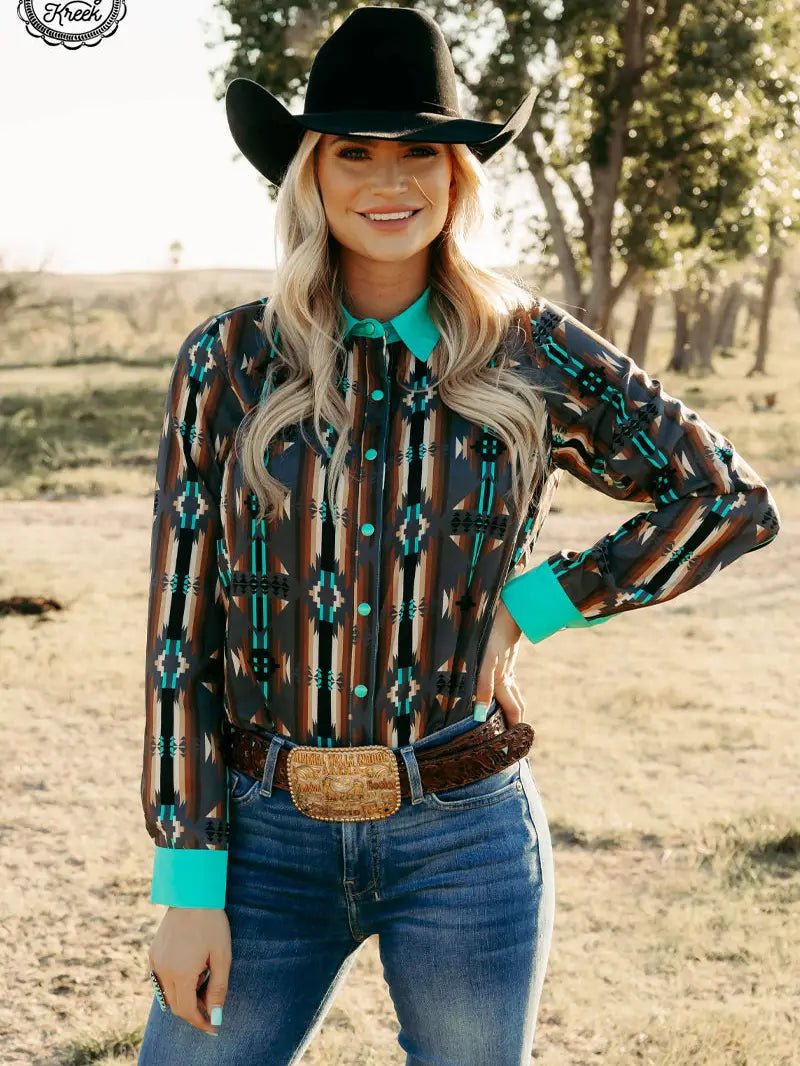 Woman modeling western Red Dirt Road Top with turquoise collar and cuffs, standing outdoors.