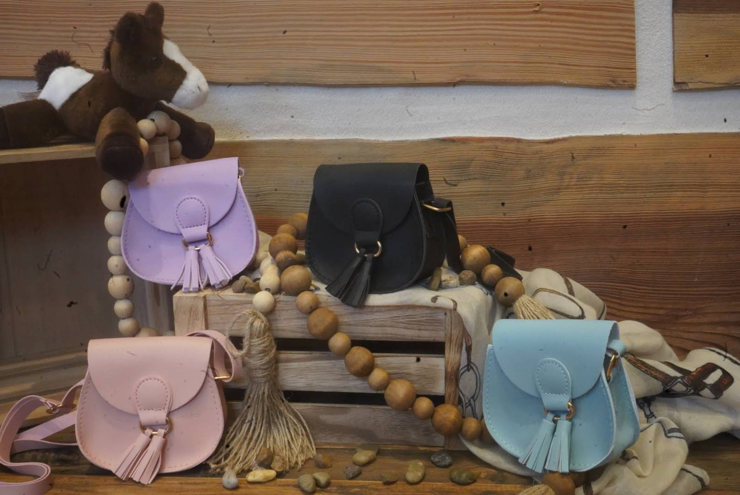Assorted kids mini crossbody purses in pastel and neutral colors.