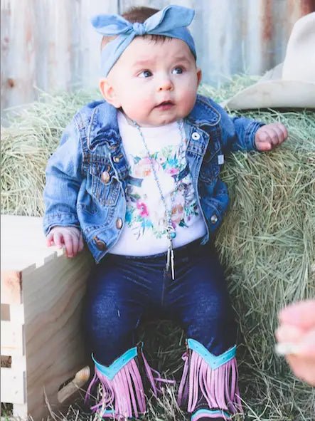 Baby wearing fringe leather boots and denim romper