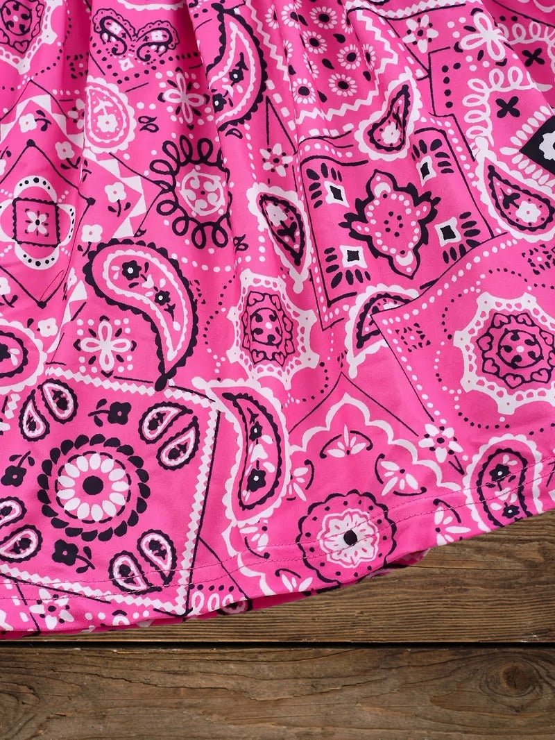 Detailed pink bandana print skirt section on girls Western cowgirl dress, fun bandana design for kids.