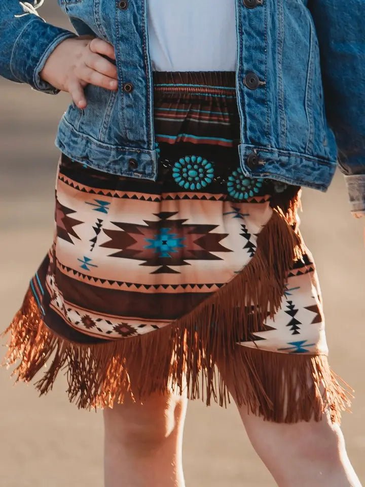 Close-up of Aztec fringe skirt with concho belt detail
