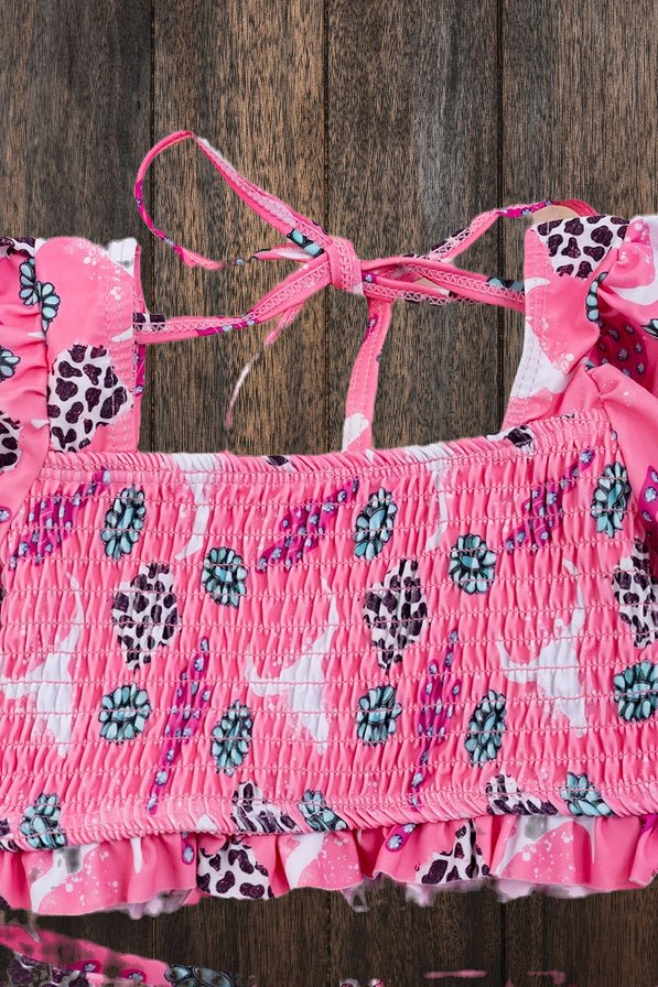 Close-up of smocked cactus print bikini top on wood