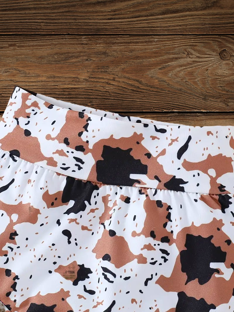 Close-up front view of cow print baby clothes shorts, matching the Wild Babe western baby outfit.