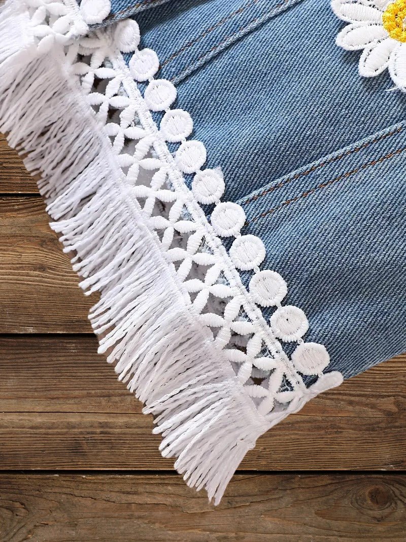 Detailed view of raw hem fringe and white lace trim on toddler denim jacket.