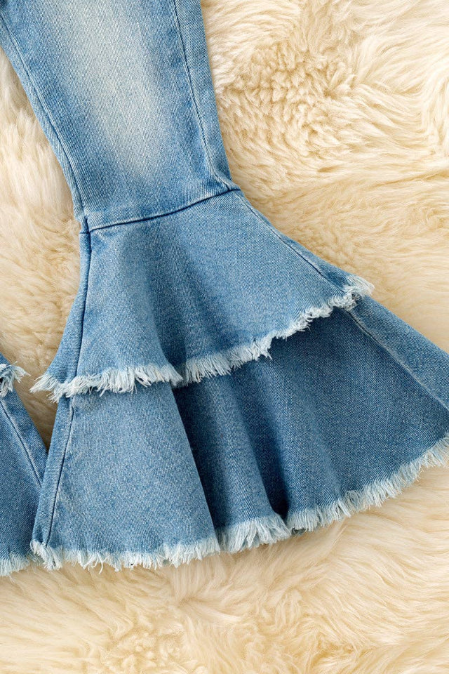 Detail of double-layered bell-bottom fringe on girls' western denim pants.