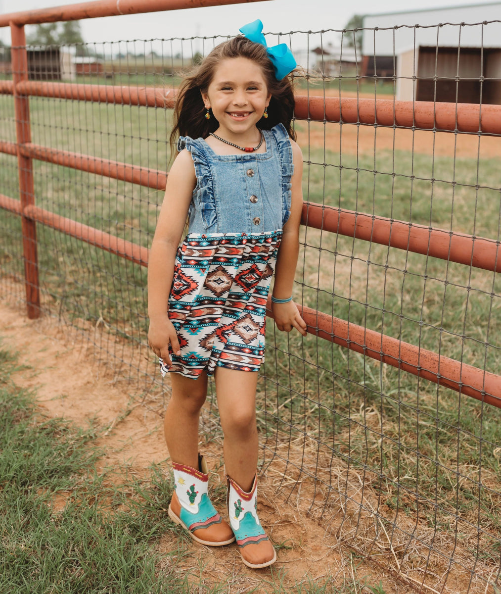 Girl wearing Pecos boots by ranch gate