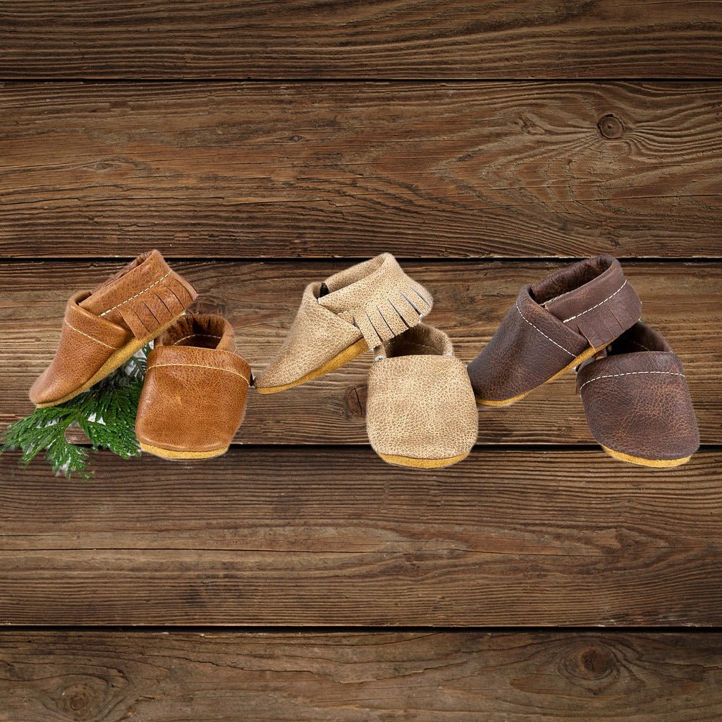 Infant cowboy shoes and baby moccasins boy styles displayed together