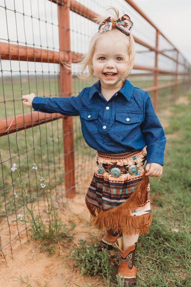Girl smiling in brown Aztec fringe skirt outdoors