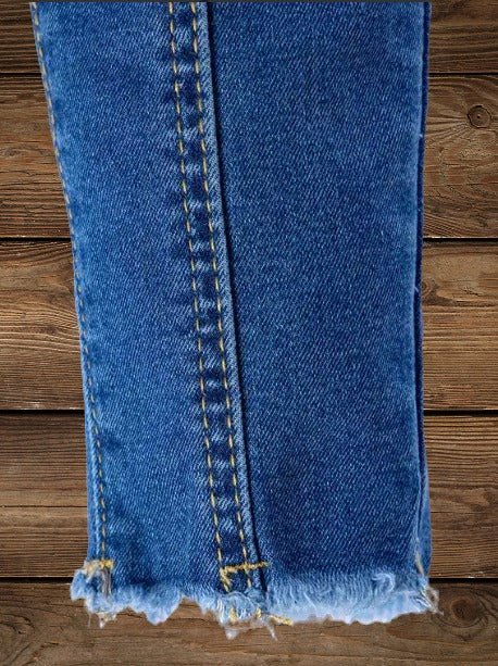 Close-up of frayed hem on Lil' Wrangler cowgirl jeans, showcasing Western style detail.
