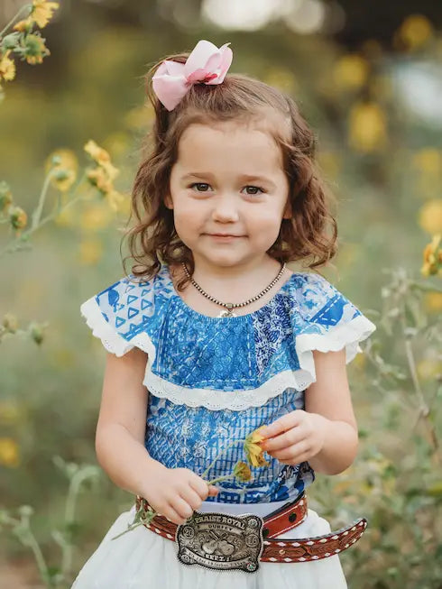 Girl wearing denim lace top with belt and white skirt outdoors
