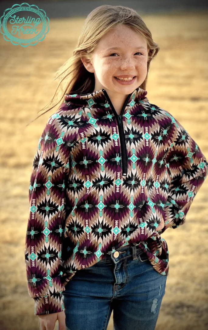 Girl wearing Mini Badlands Pullover with dark purple and turquoise design, perfect for adventure-ready western outfits and keeping warm.