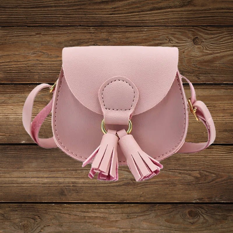 Pink mini crossbody purse for little cowgirls with tassel front.