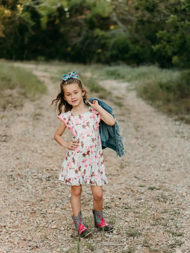 Girl wearing teal cowgirl dresses walking on trail