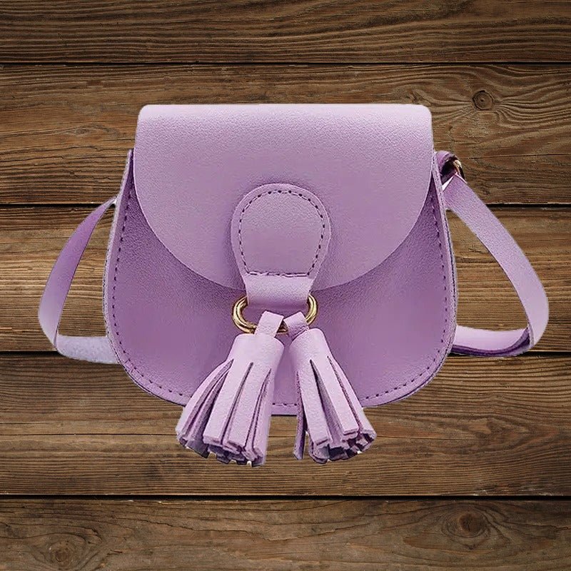 Purple mini crossbody purse with tassel detail on wood background.