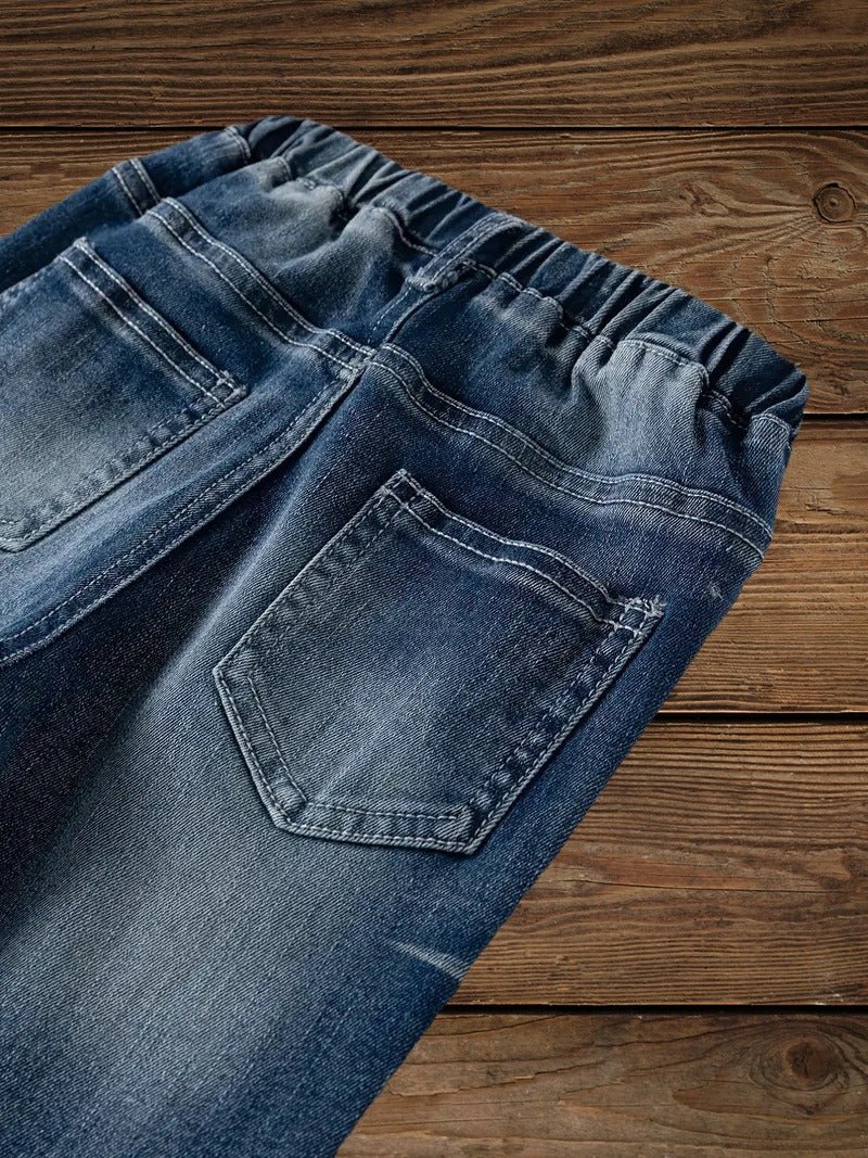 Close-up of boys' denim ripped jeans back pocket and elastic waistband.