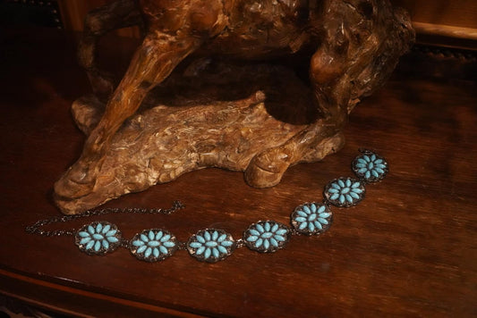 Snazzy turquoise chain belt for kids with concho design, quality children's Western belt displayed flat on horse sculpture