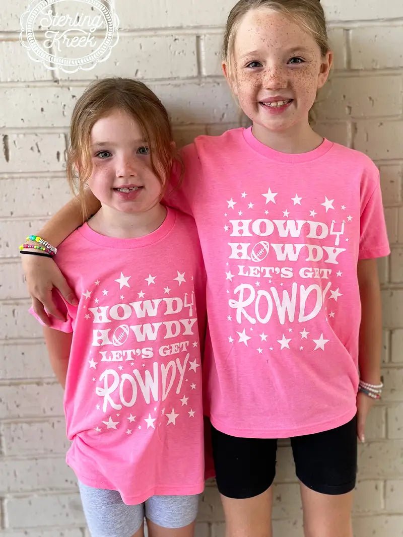 Two smiling girls wearing Star Howdy neon pink Western football shirts, perfect for game day fun.