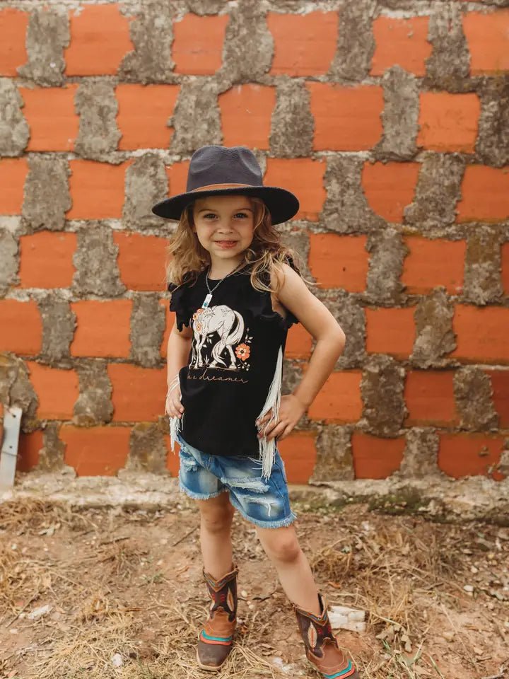 Toddler girl wearing black fringe horse shirt with cowboy hat