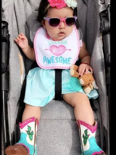 Toddler in white shirt and sunglasses wearing cowboy boots