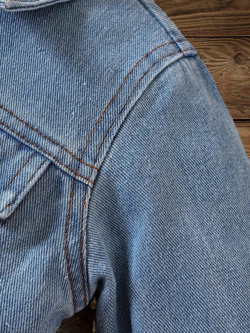 Close-up of denim jacket shoulder seam and stitching detail for toddler western style.