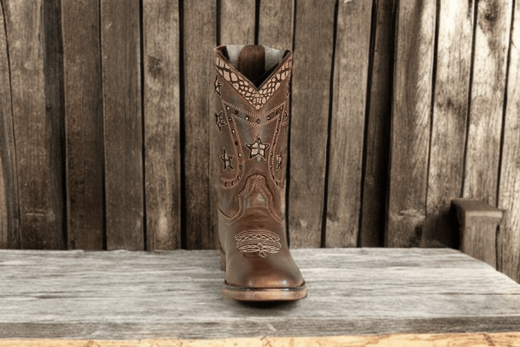 TuffRider footwear Western boots for kids shown upright on rustic wood background
