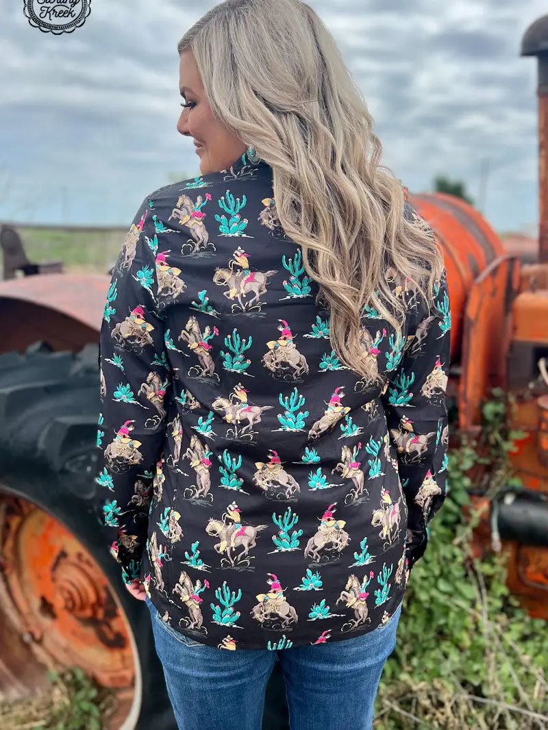 Curvy woman wearing black western grit shirt with cactus and rodeo design, back view.