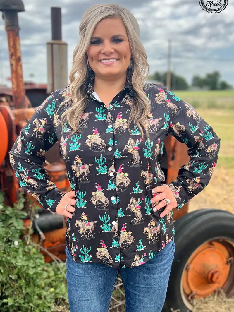 Confident woman wearing western grit black Aztec shirt, hands on hips.