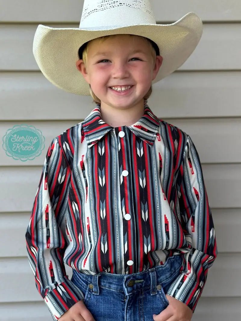 Smiling child wearing Western Roots Kids Long Sleeve Shirt, aztec-inspired button-up in red, black, and white, perfect Aztec Western shirt for kids.