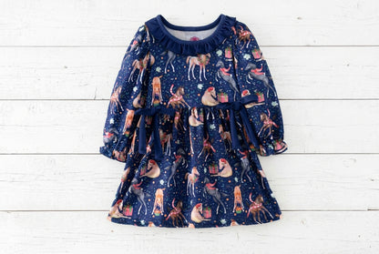 Front of a navy Christmas horse print dress with long sleeves, a ruffled neckline and two navy waist bows.