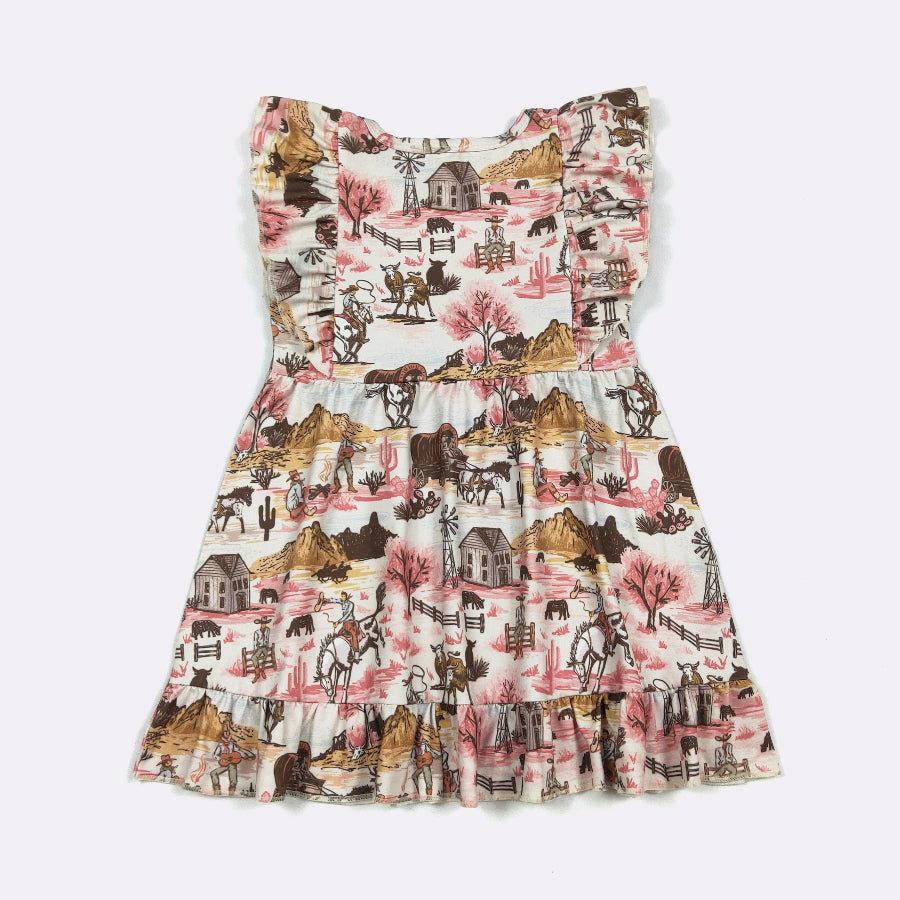 A tiered sleeveless dress with a western-themed print featuring horses, cowboy hats, saloons, and pink trees on a light background, shown flat against a light gray backdrop.
