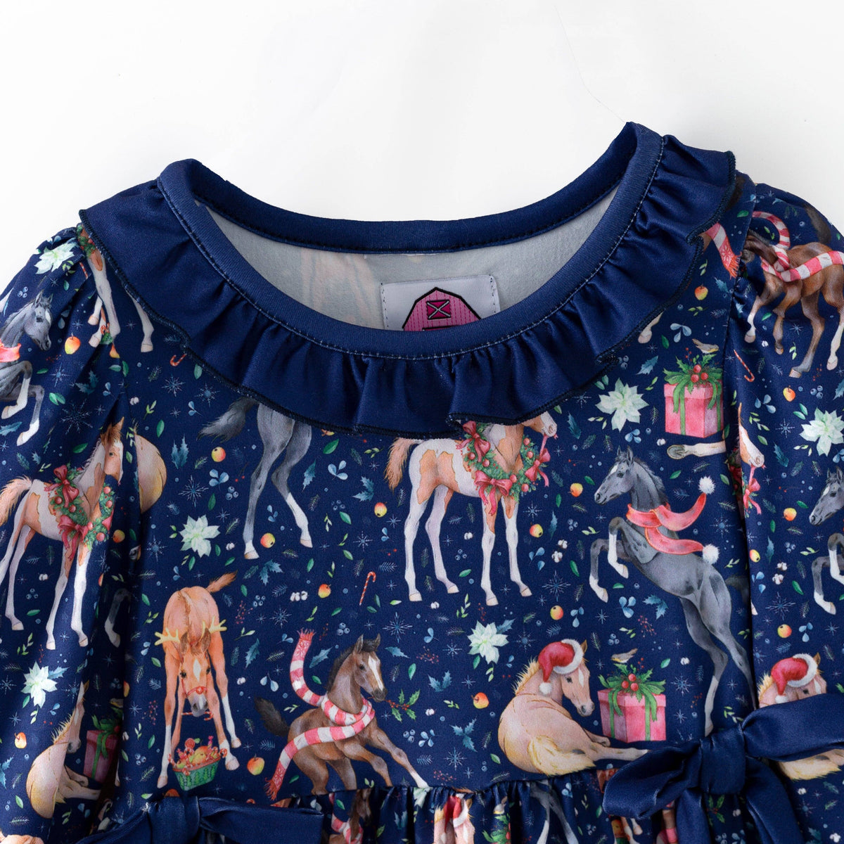 Ruffled navy neckline and holiday horse print on the Christmas dress.