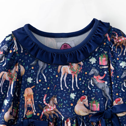 Ruffled navy neckline and holiday horse print on the Christmas dress.