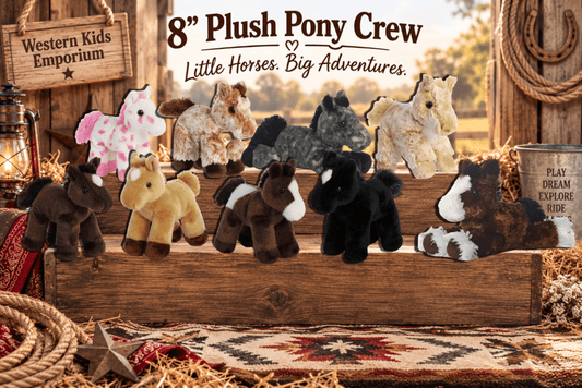 A set of nine plush pony stuffed animals in various colors and patterns, arranged on a rustic wooden crate in a western-themed setting with a sign reading '8" Plush Pony Crew' and 'Little Horses. Big Adventures.