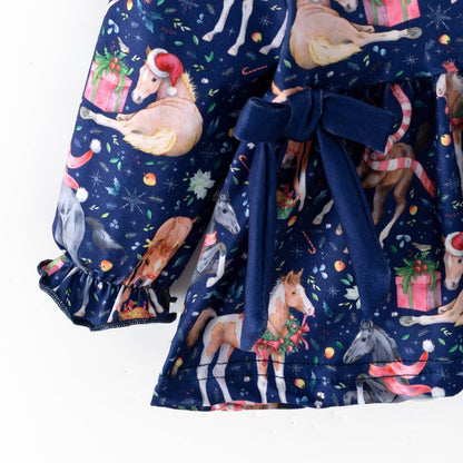 Navy waist bow, Christmas horse print and gathered sleeve cuff on the baby outfit top.