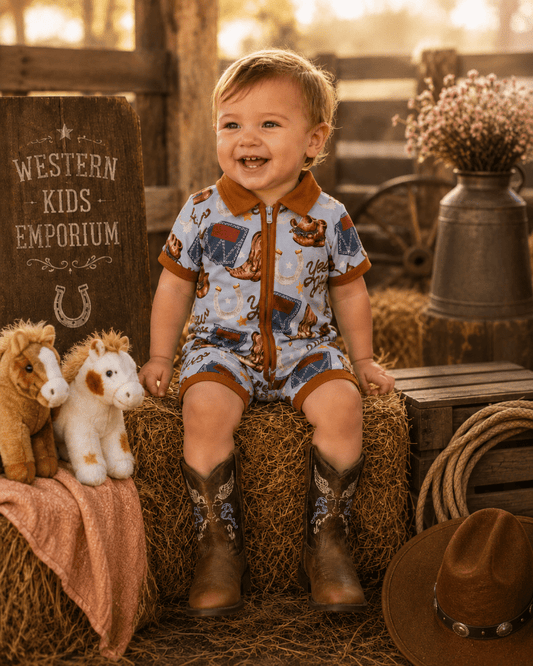 Child in a cowboy outfit sitting on a hay bale with cowboy boots, surrounded by rustic elements.