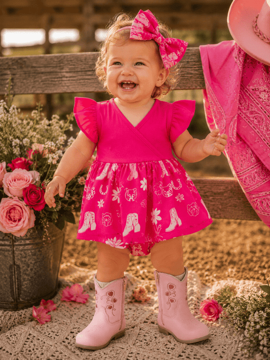 Baby cowgirl in pink romper and boots