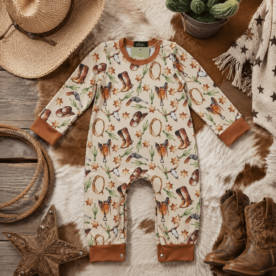 Baby romper with cowboy pattern on a wooden surface with rustic decor