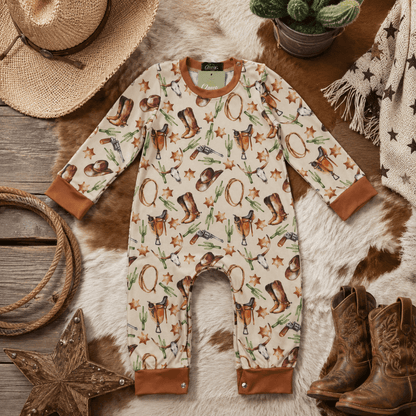 Baby romper with cowboy pattern on a wooden surface with rustic decor