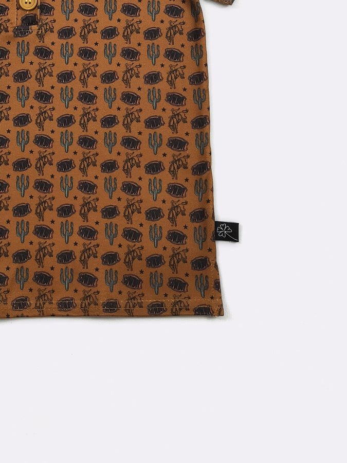 Close-up of a brown fabric with black desert pattern and a visible brand tag on a white background