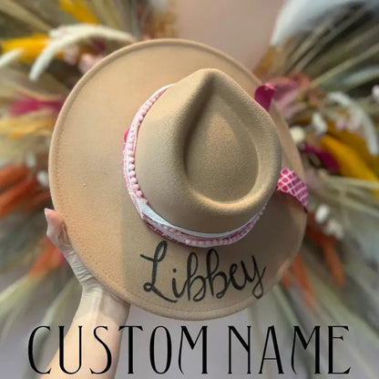 Beige hat with 'Libbey' embroidered on it against a blurred background