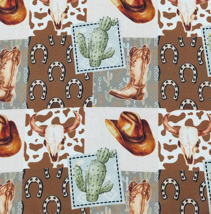 Patterned fabric with cowboy hats, boots, skulls, and cacti on a brown background.