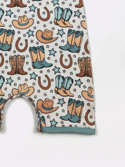 Baby romper with cowboy pattern featuring boots, hats, and stars on a white background