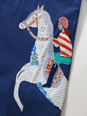 Embroidered patch of an equestrian rider on a horse with a colorful design on a blue background