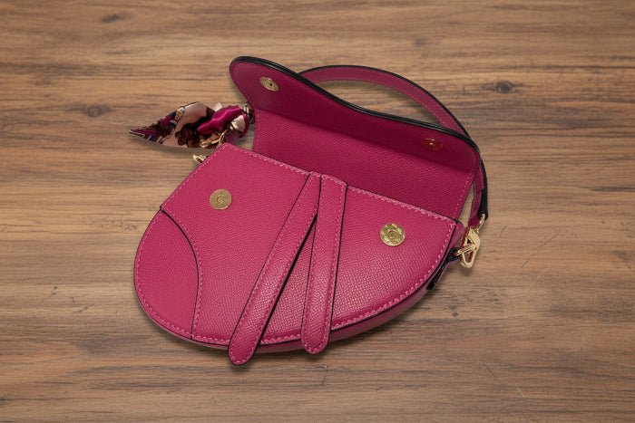 Pink handbag with gold accents on a wooden background