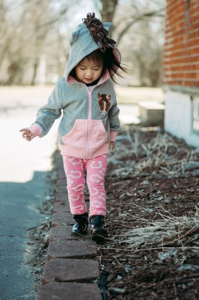 Pink horse leggings with horseshoes on a white background