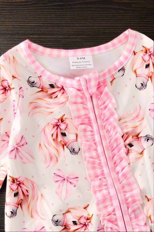 Baby romper with pink horse print and ruffled trim on a fluffy white background