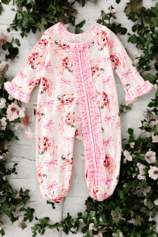 Floral baby onesie on a white background with greenery and flowers.